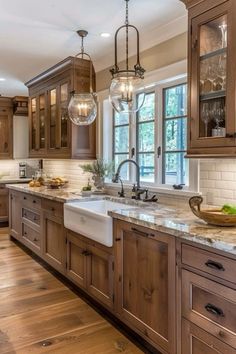 a kitchen filled with lots of wooden cabinets and counter top space next to a window