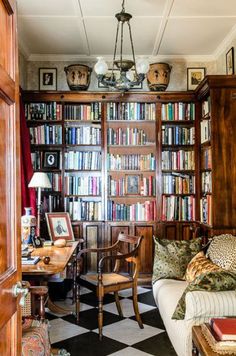 a living room filled with lots of books and furniture