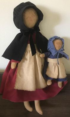 two cloth dolls are standing next to each other