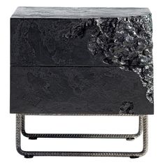 a black marble side table with metal legs and an intricate design on the top, in front of a white background