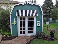 an image of a green building with white trim and windows on the front, and side door