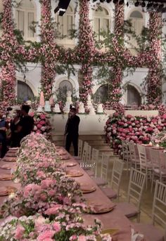 people are sitting at tables with pink flowers on them