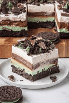 an oreo cookie cake on a white plate with cookies around it and one slice missing