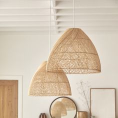 two lamps hanging from the ceiling above a mirror