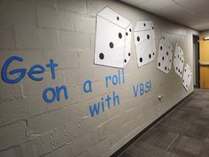 an office hallway with dice on the wall and blue lettering that says get on a roll with vegas