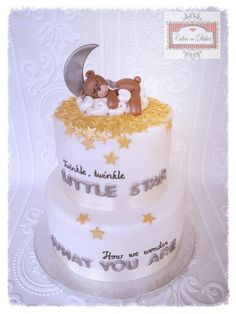 two tiered cake with teddy bears on top and the moon in the sky above it