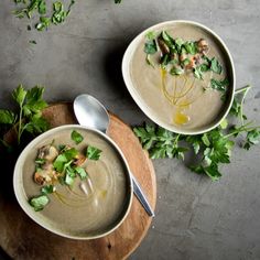 two bowls filled with soup and garnished with parsley