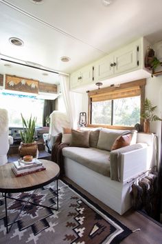 a living room filled with furniture and a fire place in front of a large window