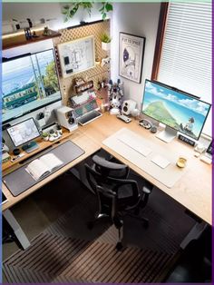 an office desk with two monitors, keyboard and mouse on it in front of a window