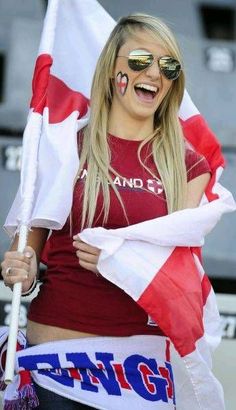 a woman with her face painted in the colors of canada and holding a canadian flag