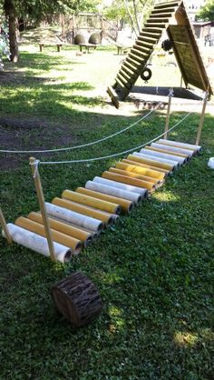 a set of steps made out of wood and rope in the grass near a tree