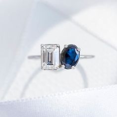 an engagement ring with two different colored stones on it, one is white and the other is blue