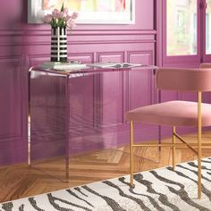 a room with purple walls and a pink chair in front of a desk that has flowers on it