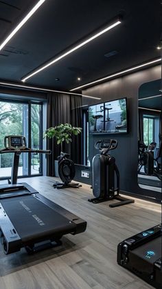 a gym with treadmills, exercise machines and mirrors in front of large windows