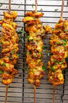 chicken skewers are being cooked on a grill