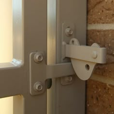 an open door with a brick wall behind it and a white handle on the side