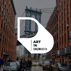 people are walking down the street in front of some tall buildings and a bridge that reads art in dumbo