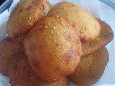 a pile of bread rolls sitting on top of a white paper towel covered in sesame seeds