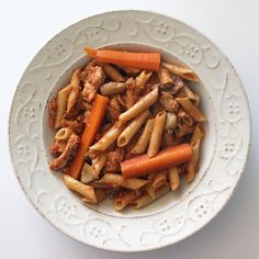 a white bowl filled with pasta and meat