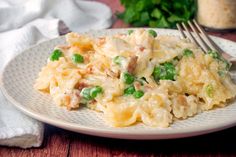 a white plate topped with pasta and peas