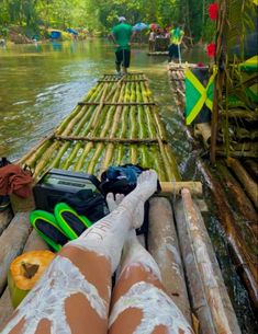 a person laying on top of a bamboo raft in the water