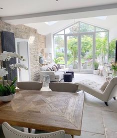 a living room filled with furniture next to a large glass window covered in white flowers