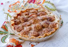 a pie sitting on top of a colorful table cloth