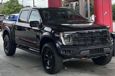 a black truck parked in front of a gas station