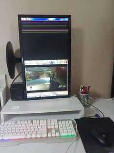 a computer monitor sitting on top of a desk next to a keyboard and mouse,