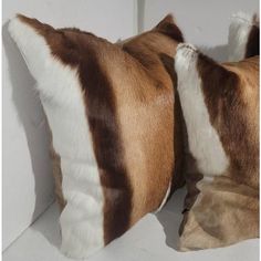 two brown and white pillows sitting next to each other