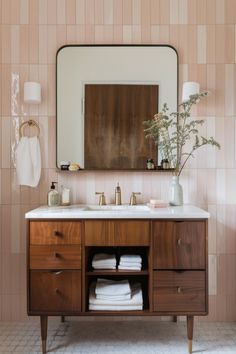 a bathroom with a sink, mirror and towel rack in it's center area