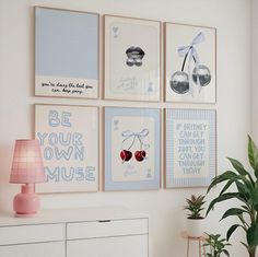 a living room with pictures on the wall and a lamp next to a dresser in front of it