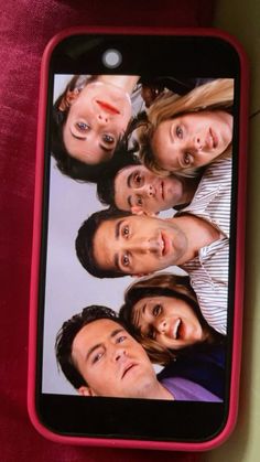 a cell phone with an image of the cast of friends on it's screen