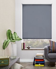 a living room with a couch, chair and window covered in blue roller shade shades