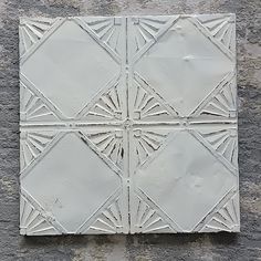 four white tiles on the side of a building