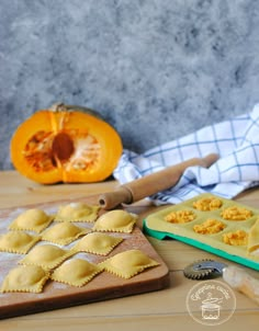 some food is laying out on a table next to a cutting board and pumpkins