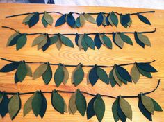 some green leaves are hanging on a wooden table