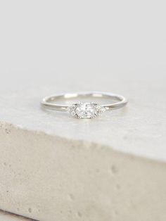 a diamond ring sitting on top of a stone slab