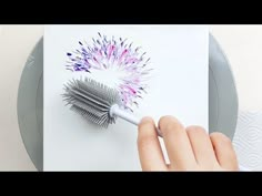 someone is holding a toothbrush in front of a piece of paper that looks like fireworks