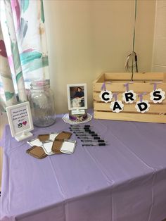 a purple table topped with cards and pictures