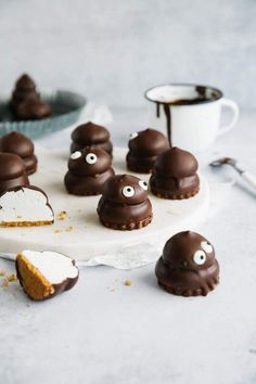 chocolate covered desserts with googly eyes and marshmallows on a plate