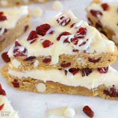 several pieces of cake with white frosting and cranberries