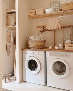 a washer and dryer sitting in a room next to each other on top of wooden shelves