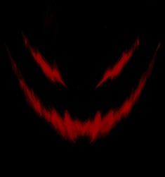 an evil looking face in the dark with bright red streaks on it's eyes