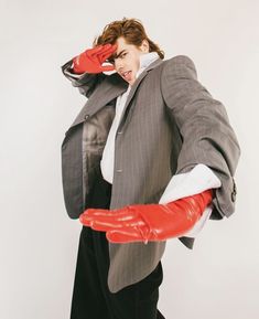 a woman in a suit and red gloves