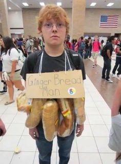 a young boy is holding bread in front of him and has a sign that says ginger bread man