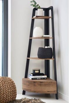 a wooden shelf with books, vases and other items on it next to a window