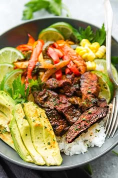 a plate with steak, rice and avocado garnished with limes