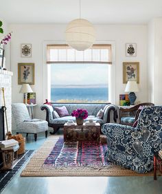 a living room filled with furniture and a fire place in front of a large window