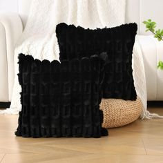 two black pillows sitting on top of a wooden floor